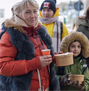 Boy and mother in winter coats holding food